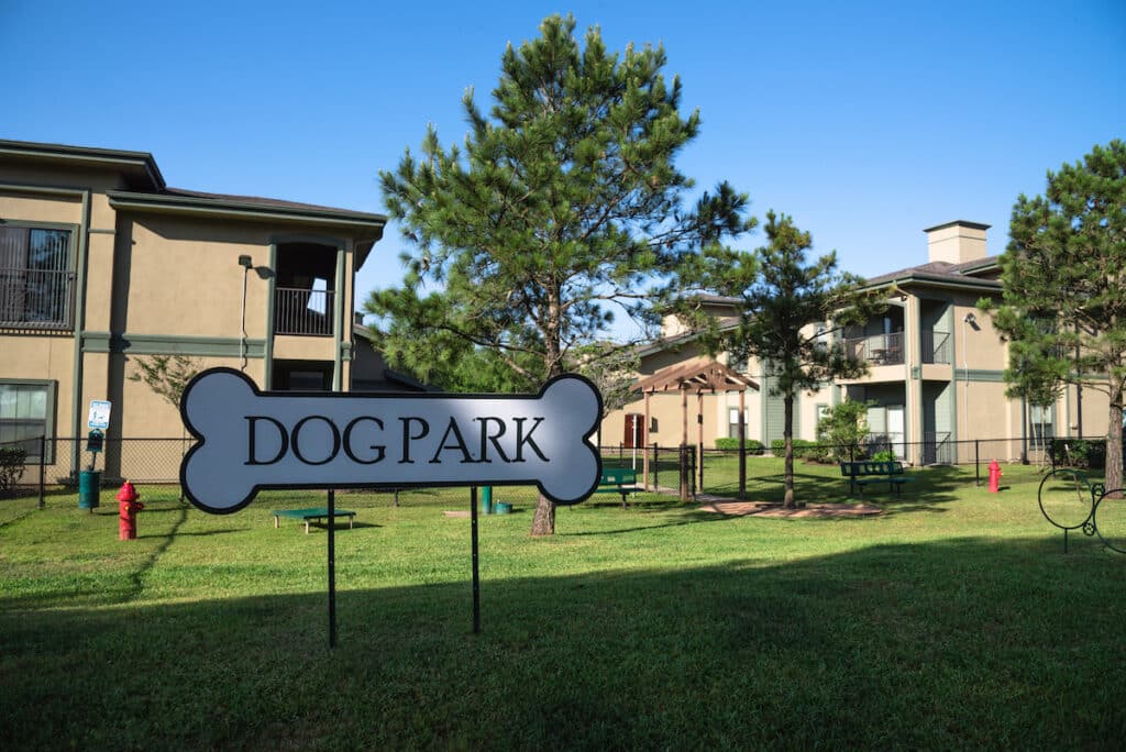 Community on-site dog park at the grassy backyard of a typical apartment complex